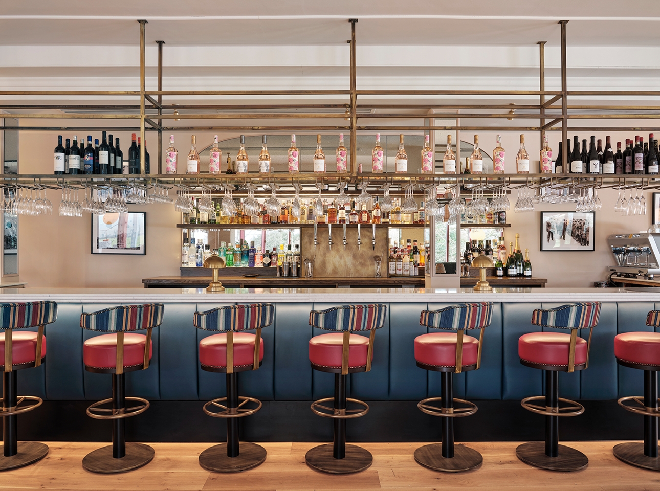 open plan bar, blue bar with with red bar stools, drinks displayed on