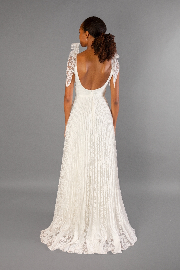 model in a line gown with pleated lace skirt and bows on shoulder